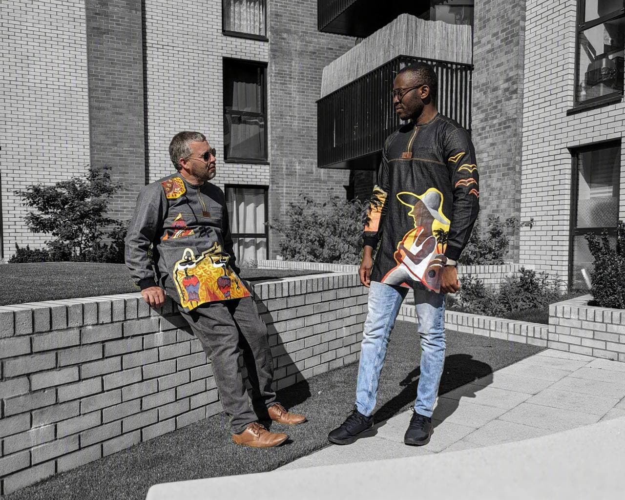 Two men in printed Denator dashiki tops on a London street, Roweiz